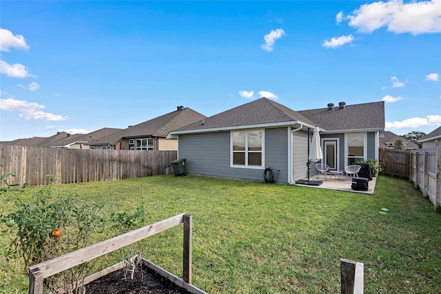 rear view of property with a yard and a patio