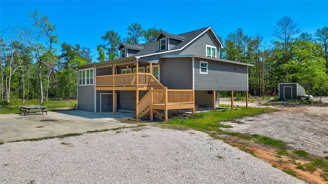 back of house with a storage unit