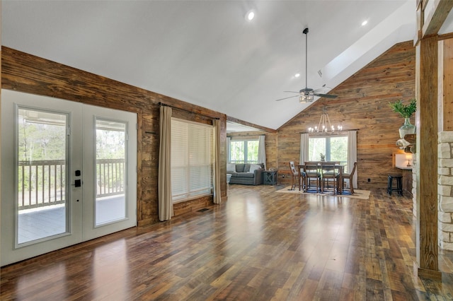 unfurnished living room featuring plenty of natural light, wood walls, and dark hardwood / wood-style floors