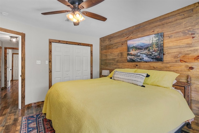 bedroom with ceiling fan, dark wood-type flooring, and a closet