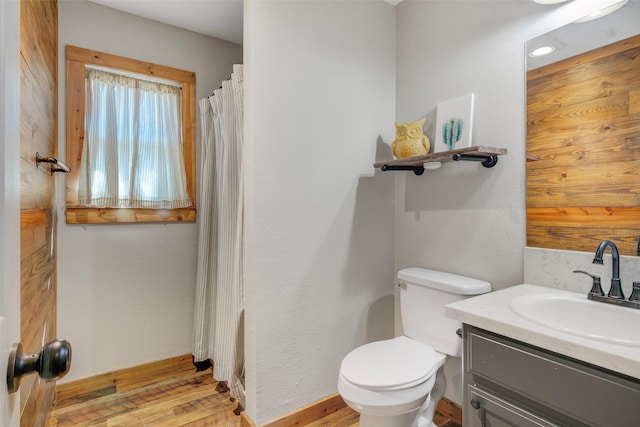 bathroom featuring a shower with curtain, vanity, wood-type flooring, and toilet