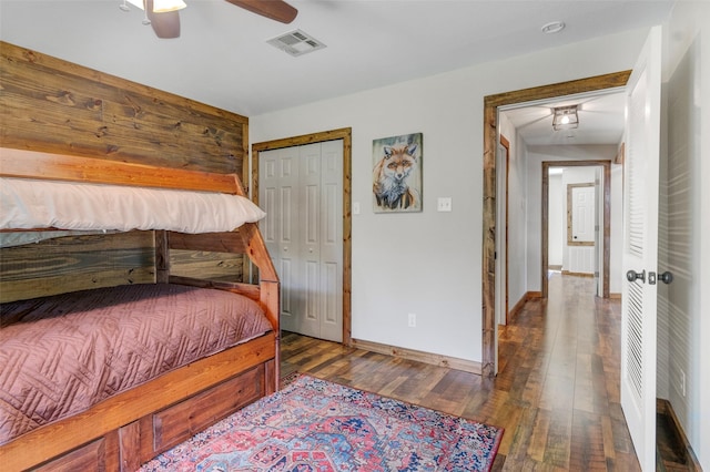 bedroom featuring ceiling fan, dark hardwood / wood-style flooring, and a closet