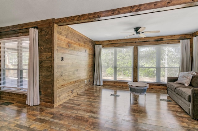 living room with ceiling fan, dark wood-type flooring, and wooden walls