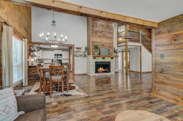 dining area with wooden walls, a fireplace, a high ceiling, and hardwood / wood-style flooring