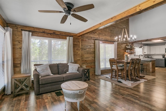 living room featuring dark hardwood / wood-style flooring, beamed ceiling, and plenty of natural light