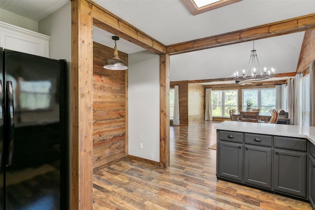 kitchen with black refrigerator, decorative light fixtures, gray cabinets, and a chandelier