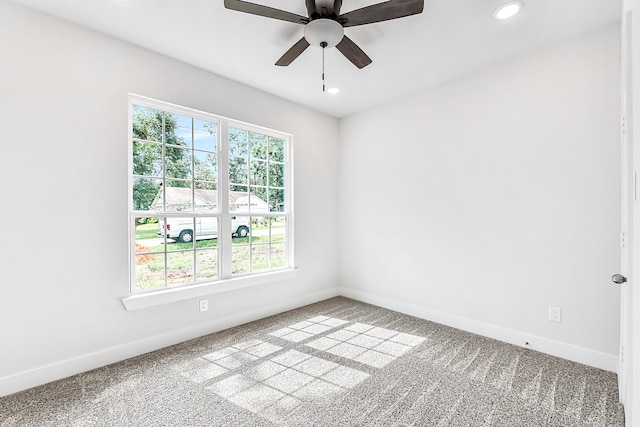 carpeted spare room with ceiling fan