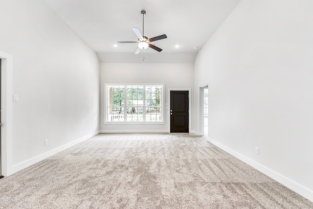 unfurnished living room featuring high vaulted ceiling, light colored carpet, and ceiling fan