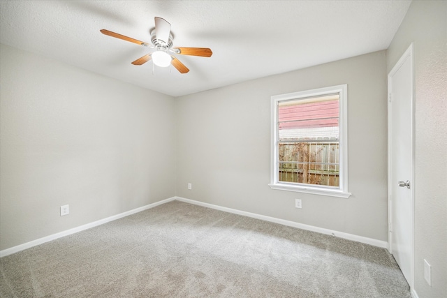 carpeted spare room featuring ceiling fan and a textured ceiling