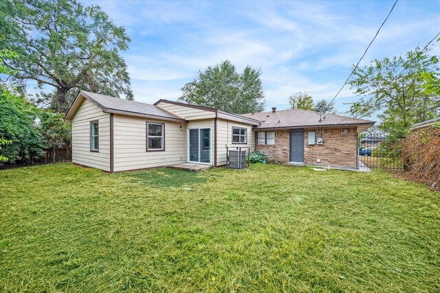 rear view of property featuring a lawn