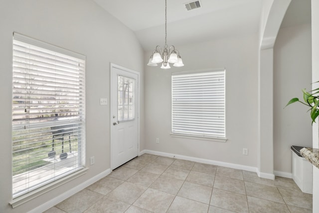 interior space with lofted ceiling, light tile patterned flooring, and a notable chandelier