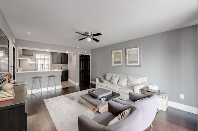 living room with ceiling fan and dark hardwood / wood-style flooring