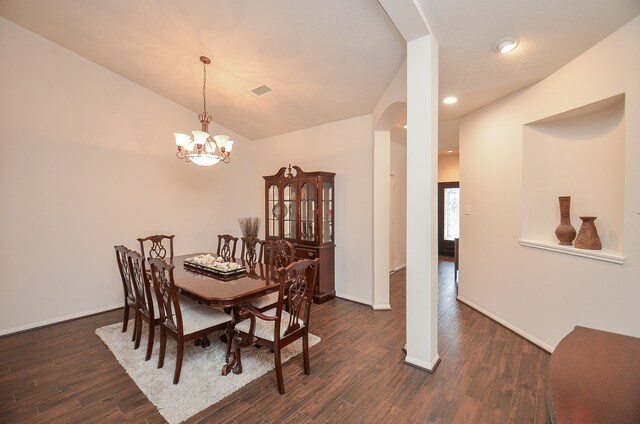 dining room with dark wood-type flooring and a notable chandelier