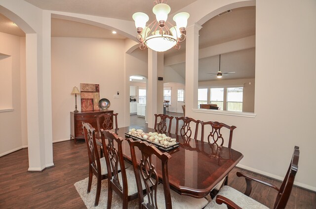 dining space featuring ceiling fan with notable chandelier, dark hardwood / wood-style flooring, and vaulted ceiling