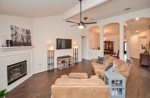 living room featuring a fireplace, dark wood-type flooring, vaulted ceiling with beams, and ceiling fan