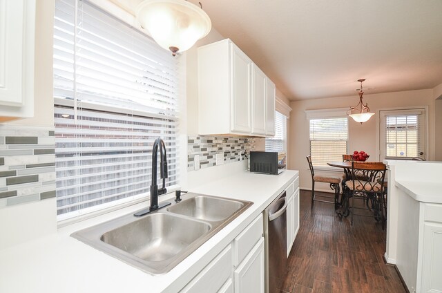 kitchen with tasteful backsplash, white cabinetry, dark hardwood / wood-style flooring, sink, and stainless steel dishwasher