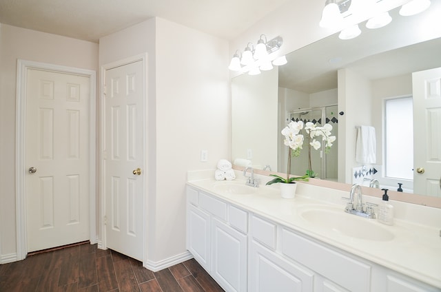 bathroom with hardwood / wood-style flooring, vanity, and an enclosed shower