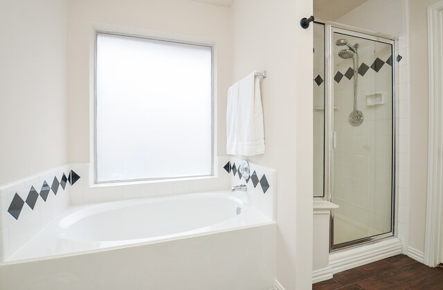 bathroom with hardwood / wood-style flooring and separate shower and tub