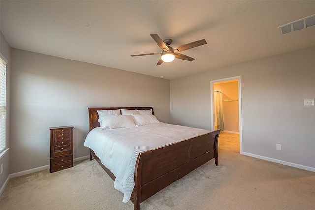 carpeted bedroom featuring ceiling fan and a spacious closet