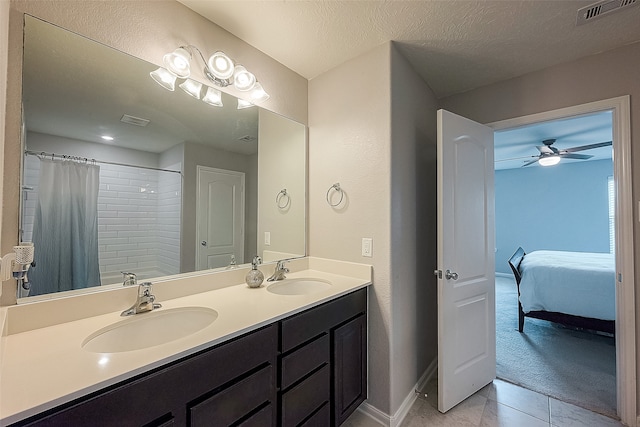 bathroom featuring ceiling fan, a textured ceiling, curtained shower, vanity, and tile patterned floors