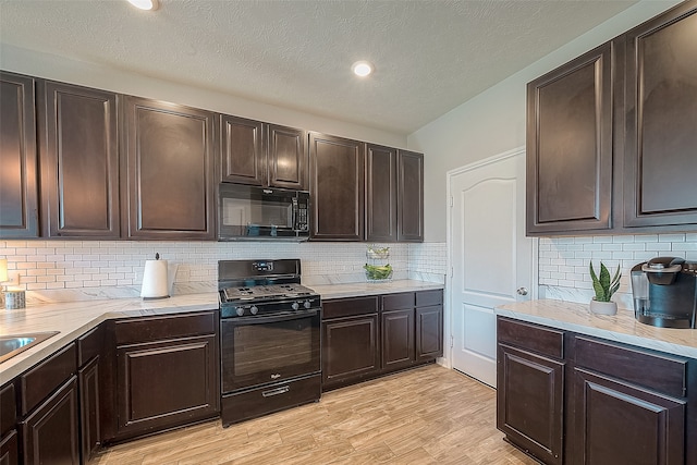 kitchen featuring black appliances, tasteful backsplash, a textured ceiling, dark brown cabinets, and light hardwood / wood-style flooring