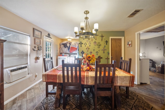 dining space with hardwood / wood-style floors, cooling unit, a notable chandelier, and washing machine and clothes dryer