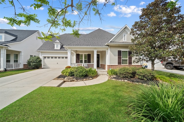 view of front of home with covered porch, a front lawn, and a garage