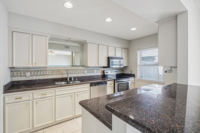 kitchen featuring sink, white cabinetry, stainless steel appliances, and dark stone countertops