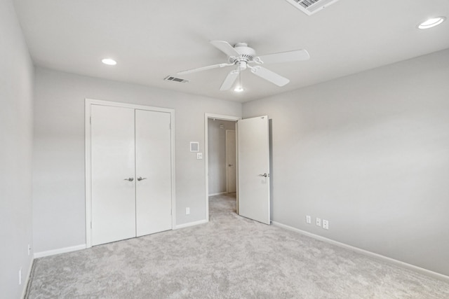 unfurnished bedroom featuring light carpet, a closet, and ceiling fan