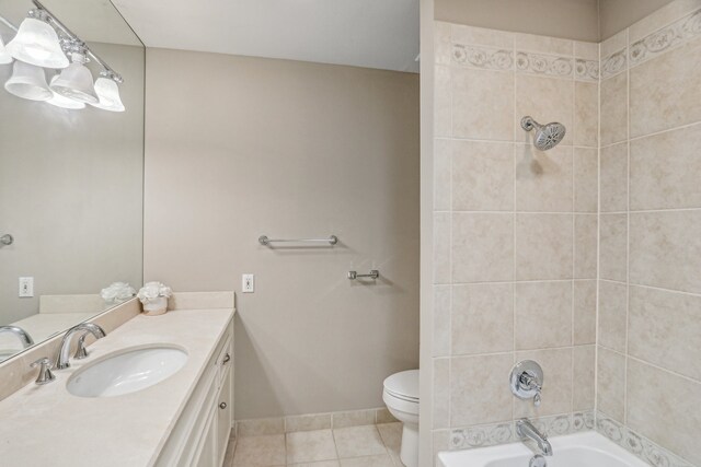 full bathroom featuring vanity, toilet, tiled shower / bath combo, and tile patterned floors