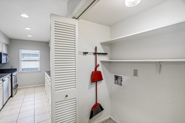 laundry area featuring hookup for a washing machine and light tile patterned flooring