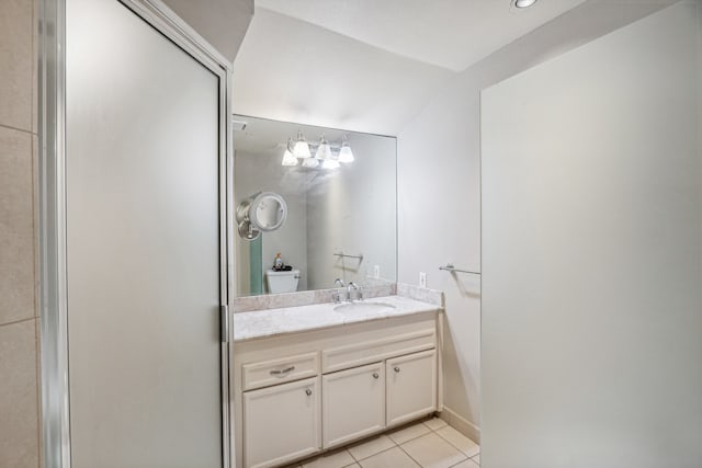 bathroom featuring vanity, toilet, lofted ceiling, and tile patterned floors