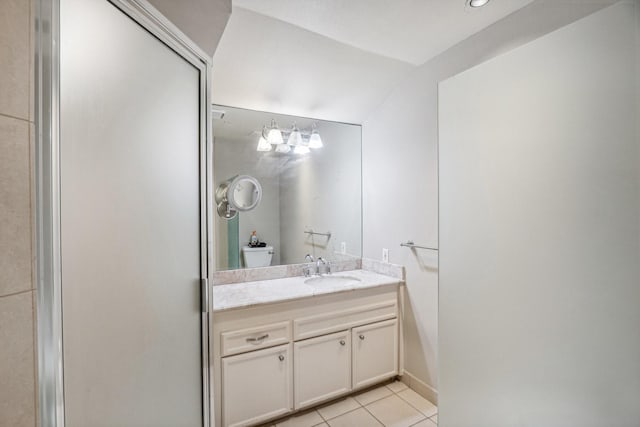 bathroom with a shower with door, vanity, vaulted ceiling, and tile patterned floors