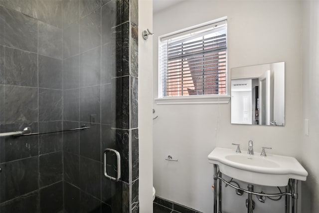 bathroom featuring toilet and an enclosed shower