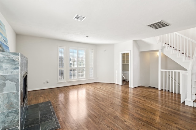 unfurnished living room featuring a fireplace and dark hardwood / wood-style floors