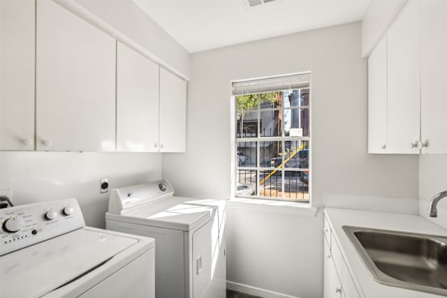 laundry area featuring cabinets, sink, and separate washer and dryer