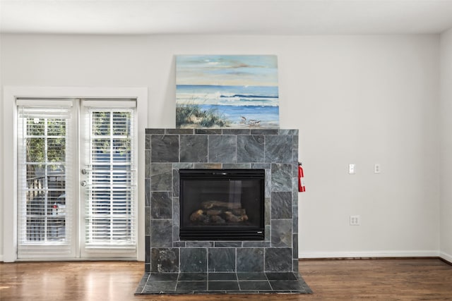 room details with a tiled fireplace and wood-type flooring