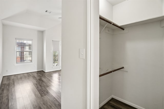 walk in closet with dark wood-type flooring