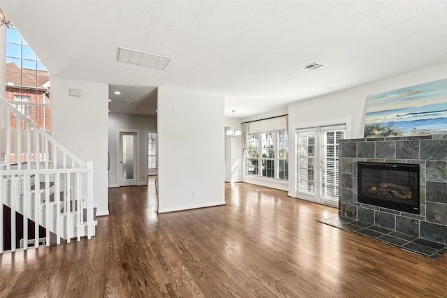 living room with wood-type flooring and a tile fireplace