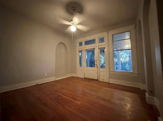 interior space with dark wood-type flooring and ceiling fan