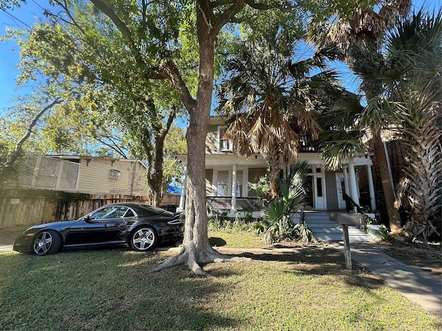 view of front of house featuring covered porch and a front lawn