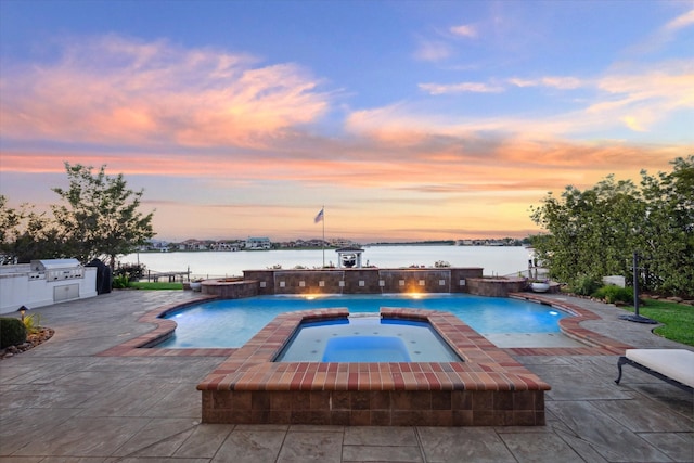 pool at dusk with a water view, pool water feature, an in ground hot tub, a grill, and a patio