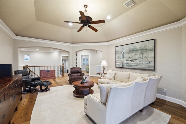 living room with ceiling fan, a textured ceiling, lofted ceiling, hardwood / wood-style flooring, and ornamental molding