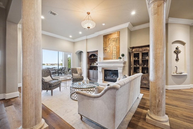 living room with decorative columns, crown molding, and hardwood / wood-style flooring