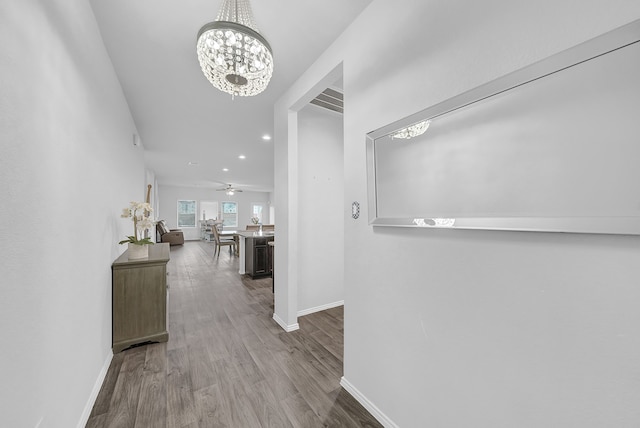 hall with a notable chandelier and hardwood / wood-style flooring