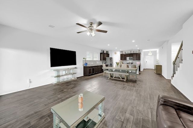 living room with ceiling fan and dark hardwood / wood-style flooring