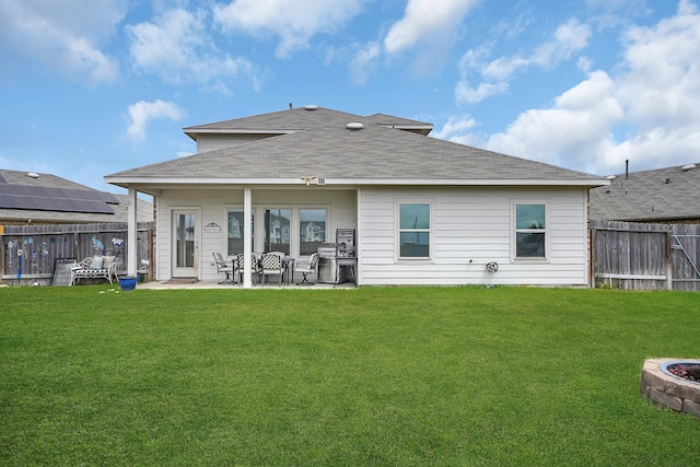 rear view of property with a yard and a patio area