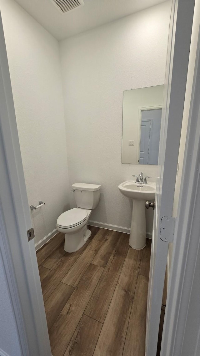 bathroom featuring hardwood / wood-style flooring and toilet