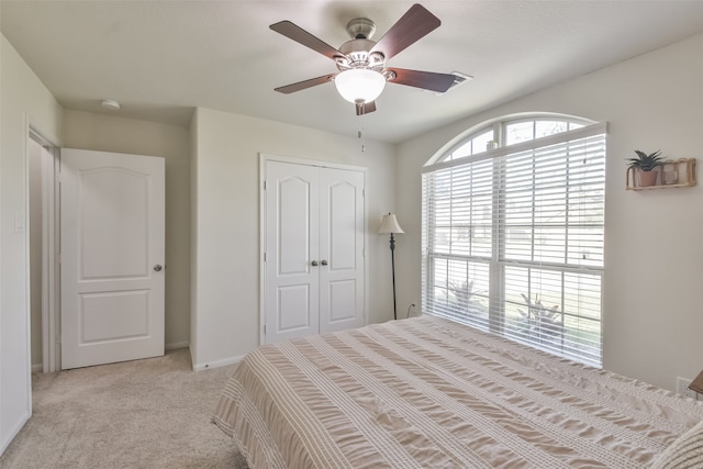 unfurnished bedroom featuring a closet, ceiling fan, and light colored carpet