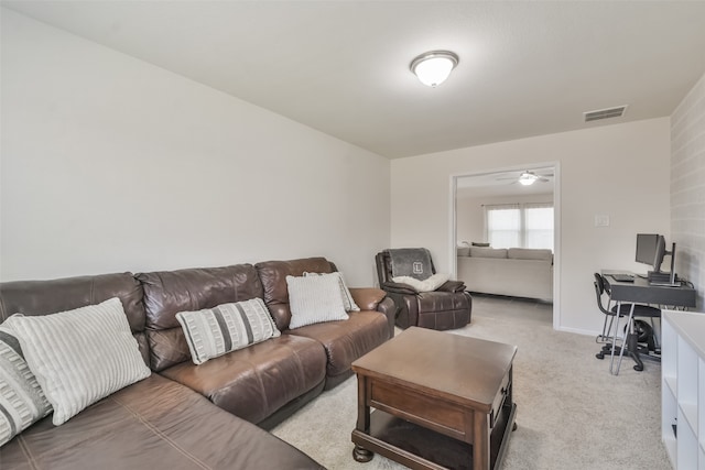 carpeted living room with ceiling fan